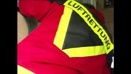 Ein Mann mit einer Rettungsjacke auf der "Luftrettung" geschreben steht  