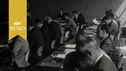 Zahlreiche Männer in einem Seminarraum 1965 bei einem Kolloquium  