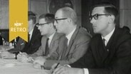 Fünf Finanzexperten hintereinander an einem Tisch bei einer Tagung 1965  