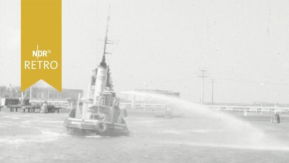 Hafenschlepper in Brunsbüttel demonstriert Einsatz einer Schaumkanone (1964)  