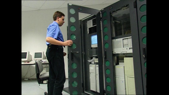 Ein Mann öffnet die Tür zu einem Serverraum  