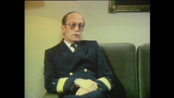 Admiralarzt Karl-W. Wedel sitzt auf einem Sofa  