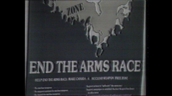 Plakat mit der Aufschrift "End the arms race"  
