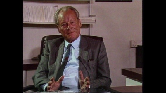 Willy Brandt sitzt an einem Schreibtisch  