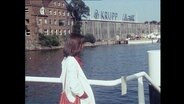 Eine Frau steht vor den Krupp-Werken in Kiel  