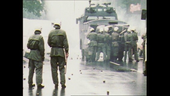 Polizisten stehen hinter einem Wasserwerfer (Archvibild)  