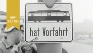 Arbeiter montiert ein Schild "Straßenbahn hat Vorfahrt" in Hamburg 1963  