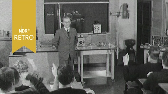Physiklehrer vor einer Tafel im Unterricht einer Oberstufenklasse 1963  