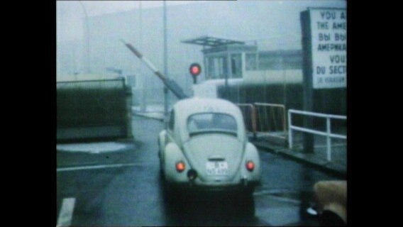 Ein Auto fährt durch die Grenze zwischen Ost-und Westberlin  