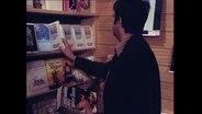 Ein Mann schaut sich in einem Buchladen um  