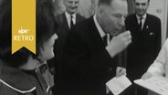 Helmut Lemke, Ministerpräsident von Schleswig-Holstein, nimmt ein Glas mit einer Schluckimpfung im Rahmen der Massenimpfung gegen Polio 1964  