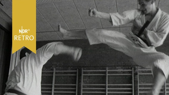 Zwei Karatekämpfer bei einer Vorführung im Training 1965, ein Tritt in hohem Sprung  