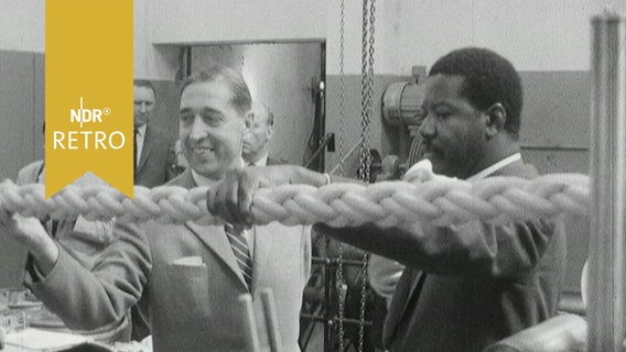 Delegationsteilnehmer bestaunen bei einer Werksbesichtigung in Bremen ein Tau (1965)  