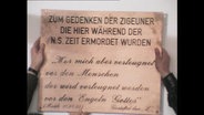 Schild mit der Aufschrift "Im Gedenken der Zigeuner die hier während der NS-Zeit ermordet wurden"  