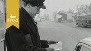 Grenzer kontrolliert Papiere an einem Autofenster 1963  