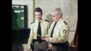 Zwei Polizisten bei einer Einsatzbesprechung  