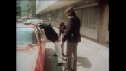 Fahnder der Polizei durchsuchen einen Mann (Archivbild)  