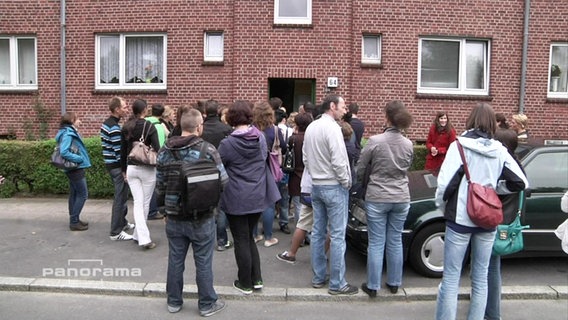 Menschen stehen für eine Wohnungsbesichtigung Schlange  