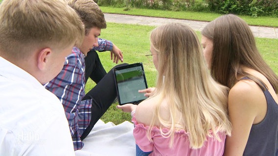 Jonah, Hannes, Gesa und Hannah zeigen ihre Online-Petition zur Rettung des Freibades in Bevern.  