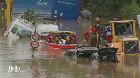 Rettungskräfte bei Bergungsarbeiten im Hochwasser.  