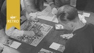 Schüler in den 50er-Jahren an einem großen Maltisch im Unterricht  