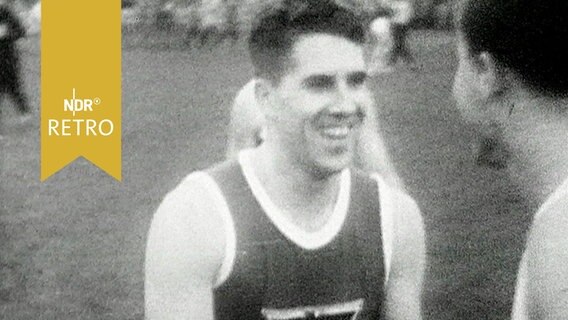 Sprinter Heinz Fütterer nach seinem letzten Laufmeeting im Karlsruher Wildparkstadion, begrüßt einen Kollegen (1959)  