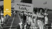Nutzer der "Heimvolkshochschule Leck" mit Schild beim Einzug zur Einweihung des neuen Sportstadions in Leck/ Schleswig-Holstein (1963)  
