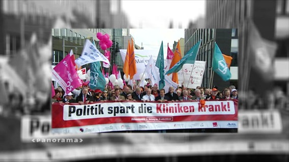 Demo-Banner mit der Aufschrift "Politik spart die Kliniken krank"  