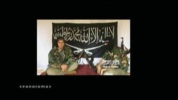 Zwei Islamisten sitzen nebeneinander auf dem Boden  