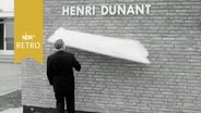 Ein Mann hat den Verhüllungsstoff vom Schriftzug "Henri Dunant" bei der Eröffnung einer gleichnamigen Sanitätsstation in der Röttger-Kaserne herunter gezogen (1963)  