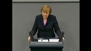 Angela Merkel an einem Rednerpult  