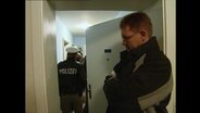 Die Polizei steht in einem Wohnungsflur  