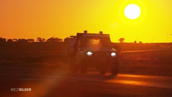 Ein Geländewagen fährt durch das australische Outback.  
