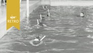 Taucher üben mit Schnorcheln in einer Reihe in einem Schwimmbecken (1964)  