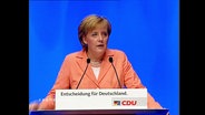 Angela Merkel an einem Rednerpult  