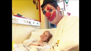 Ein "Clown-Doktor" bei einer jungen Patientin  