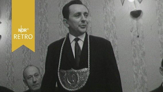Der Jeveraner Püttbierkönig 1964 bei einer Rede, mit der entsprechenden Plakette um den Hals  
