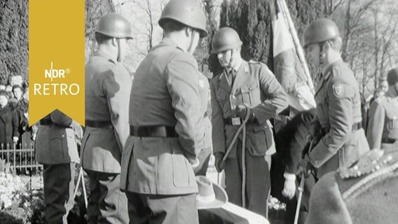 Soldaten lassen einen Sarg eines ehemaligen Kommandeurs der Schutztruppen Deutsch-Ostafrikas ins Grab auf dem Dorffriedhof von Pronstorf (1964)  