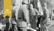 Soldaten lassen einen Sarg eines ehemaligen Kommandeurs der Schutztruppen Deutsch-Ostafrikas ins Grab auf dem Dorffriedhof von Pronstorf (1964)  