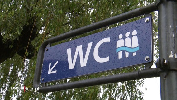 Ein Schild mit der Aufschrift "WC" und einem Symbol für alle Geschlechter.  