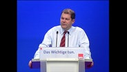 SPD-Politiker Olaf Scholz an einem Rednerpult  