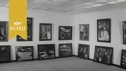 Ausstellungsraum im Emil-Nolde Museum Niebüll 1964: Bilder hängen an den Wänden, darunter stehen Bilder auf dem Fußboden  