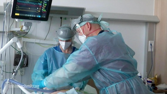 Pflegekräfte in Schutzkleidung bei der Arbeit im Krankenhaus.  