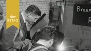 Schweißer und Lehrling bei der Arbeit in einer Werkstatt (1964)  