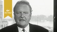 Hamburgs Zweiter Bürgermeister Edgar Engelhard bei einem TV-Interview im Rathaus, dahinter Blick auf die Alsterarkaden (1964)  