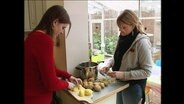Zwei Schülerinnen schälen Kartoffeln  
