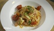 Plated spaghetti with shrimps and cherry tomatoes.  