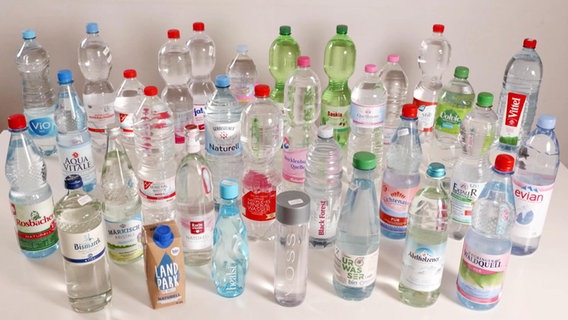 Flaschen von diversen Mineralwasserherstellern stehen auf einem Tisch.  