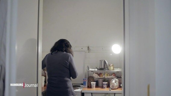 Eine Frau steht in einer Küche.  