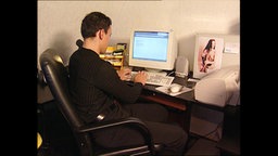 Ein junger Mann vor einem Computer  